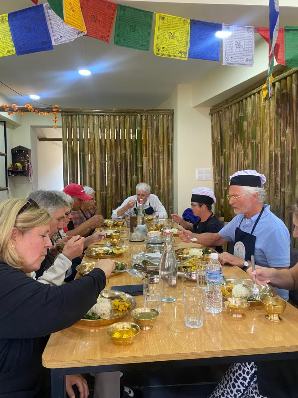 ravelers dining Nepali-style using brass utensils and floor seating